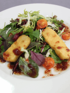 Plat de la Carta amanida de brie arrebossat amb enciam i tomata i salsa de fruits vermells